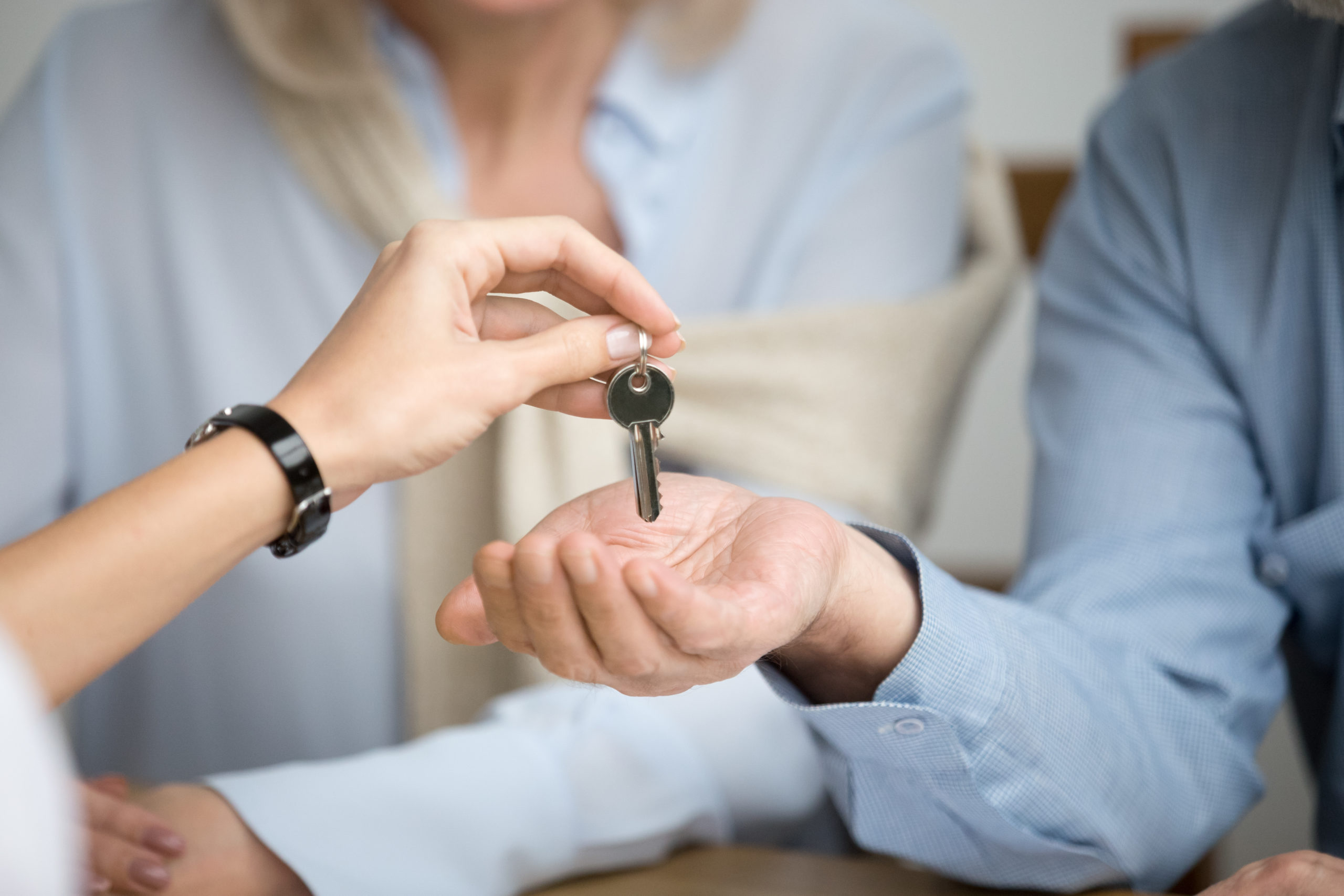 Couple of homeowners getting key to new house from realtor
